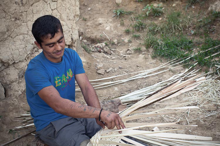 Male gypsy weaving a basket